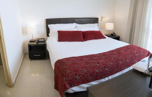 布卡拉曼加Confortable y Tranquilo Aparta Suite en el Corazón de Bucaramanga, Exterior con hermosa vista sobre la ciudad的卧室配有一张大白色的红色床单