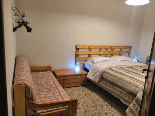 Miroglioda Alessandra e Fabio的一间卧室配有两张床和一张带灯的桌子