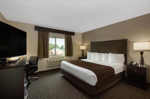 苹果谷苹果谷阿美瑞辛套房酒店的配有一张床和一台平面电视的酒店客房