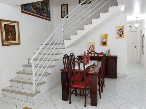 塞尔苏拉穆斯州长镇Casa de Praia em Palmas的一间带桌子和楼梯的用餐室