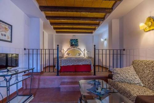 圣克莱门特Hostal Nuevo Milán I的一间卧室配有一张床、一张沙发和一张桌子