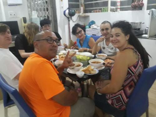 胡志明市赛贡奈民宿（特兰庄园） 的一群坐在桌子旁吃食物的人