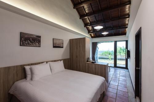 马公貝富門旅館 - 澎湖灣行旅的卧室配有白色的床和窗户。