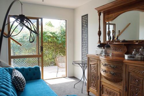 陶朗加The Loft Matua的客厅配有蓝色的沙发和木制梳妆台