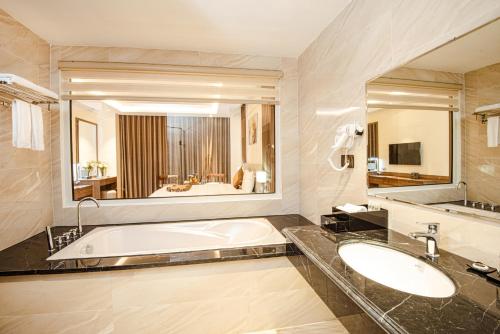 YenManh Quan Luxury Hotel的一间带浴缸和大镜子的浴室