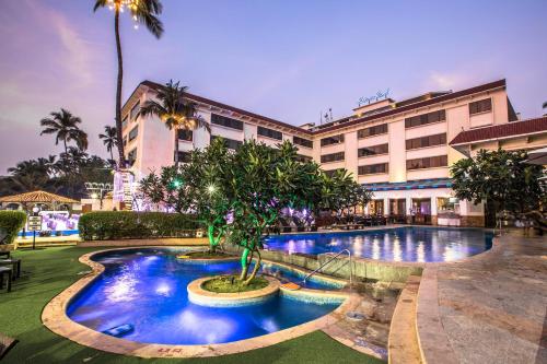 孟买Sun-n-Sand Mumbai Juhu Beach的大楼前有游泳池的酒店
