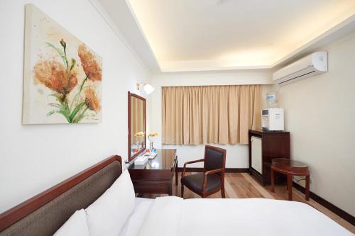 新竹水蜜桃时尚旅店的配有一张床、一张桌子和一张桌子的酒店客房
