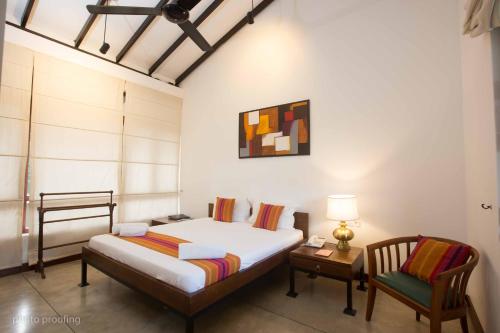 贾夫纳Jaffna Heritage Villa的卧室配有1张床、1张桌子和1把椅子