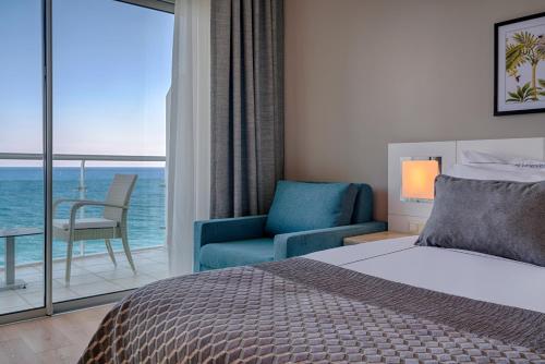 贝尔迪比Corendon Playa Kemer Hotel的一间带一张床和一把椅子的卧室以及一个阳台