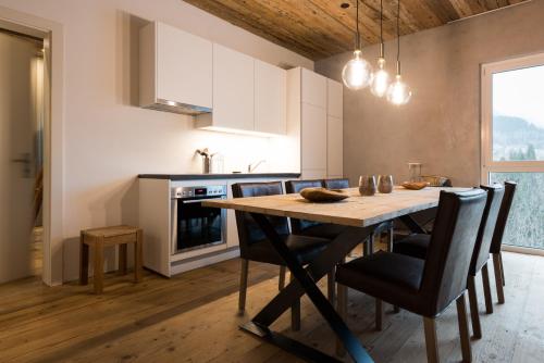 菲施WOO® Loft Resort的厨房配有木制餐桌和椅子