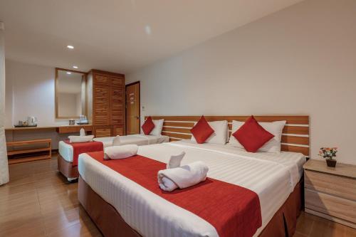 普吉镇普吉岛缇帕蒂酒店的一间卧室配有两张带红白色枕头的床