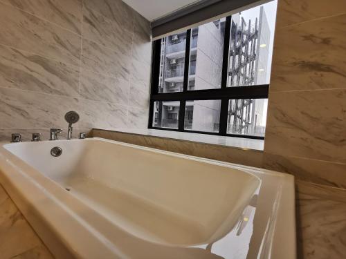 马六甲Thermospace Imperio A-17-19 Melaka City的带窗户的浴室内的白色浴缸