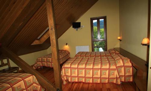 VíuHotel, Bungalows y Camping Viu的阁楼卧室设有两张床和楼梯。