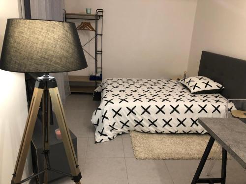芒特拉若利Studio 104的一间卧室配有一张床、一盏灯和一张桌子