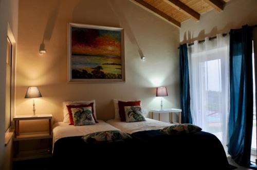 圣路易斯Cal Velho - Holiday Lodge的卧室配有一张床,墙上挂有绘画作品