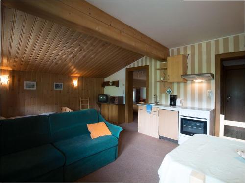 乌滕多夫布兰戴克旅馆的一间带蓝色沙发的客厅和一间厨房