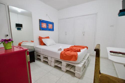 巴兰基亚QuillaHost Guesthouse的一间卧室配有一张带橙色毯子的床