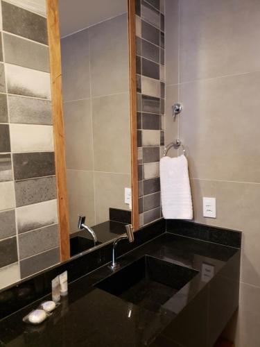 圣米格尔-杜斯米拉格里斯Pousada Ricoco的浴室设有黑色水槽和镜子