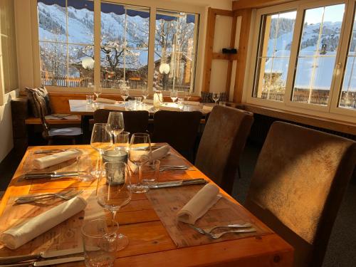 塞德龙Mountain Lodge Sedrun的用餐室配有带酒杯的桌子