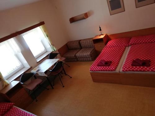 泽勒兹纳·鲁达Penzion Rudolfovna的客房设有床、书桌和沙发。