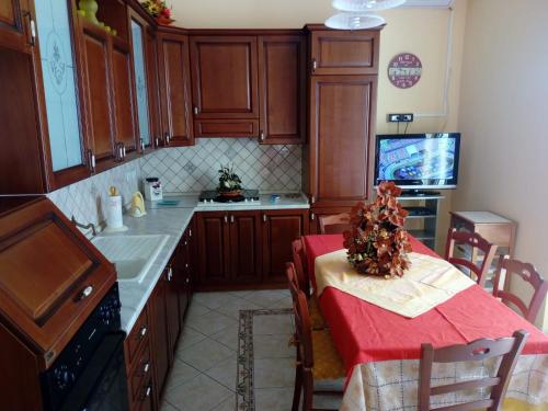 雷阿尔蒙特VILLETTA SCALA DEI TURCHI a SOLI 40 MT DAL MARE的厨房配有木制橱柜和一张带红色桌布的桌子。