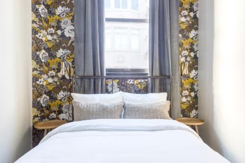 旧金山Sonder Hayes Valley的一间卧室设有床铺和一个带花卉壁纸的窗户。