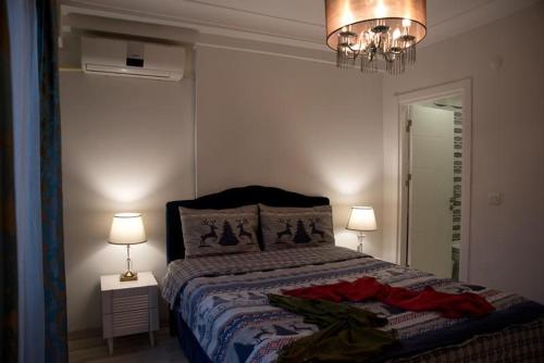 伊斯坦布尔Nupelda Residence Hotel的一间卧室配有一张床、两盏灯和吊灯。