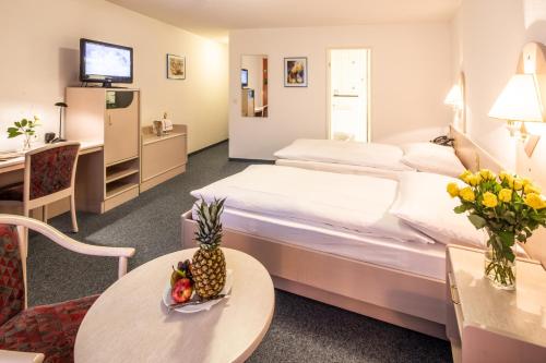 索洛图恩Gasthof Enge Self Check-In Hotel的酒店客房配有一张床铺和一张桌子。