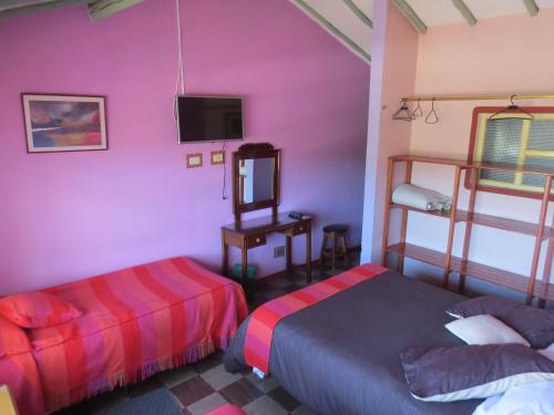 蒙圭Hotel Portón De Ocetá的一间带两张床的卧室和一台电视