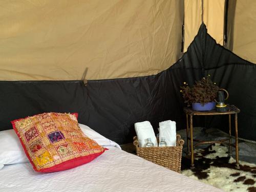 萨兰托Refugio Nidos del Condor Cocora的帐篷内的一张床位,配有枕头和毛巾