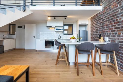 开普敦Urban Artisan Luxury Suites by Totalstay的厨房设有砖墙和桌椅