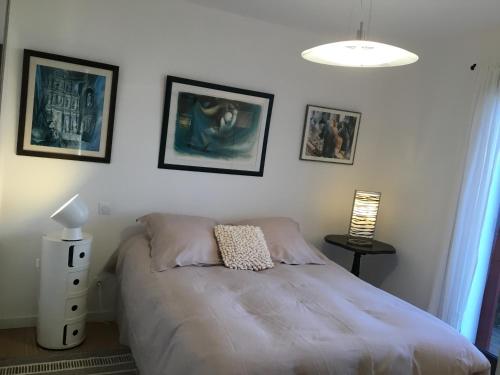 Uhart-CizeMaison Fleurie的卧室配有一张床,墙上挂有图片