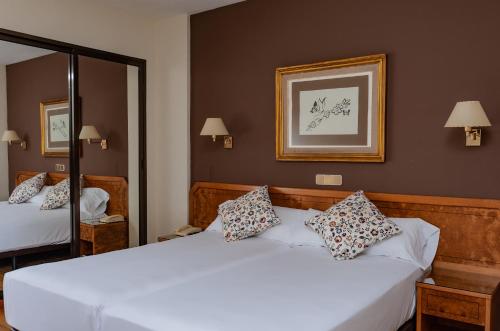 阿维拉唐卡梅洛酒店的一间卧室配有两张床和镜子