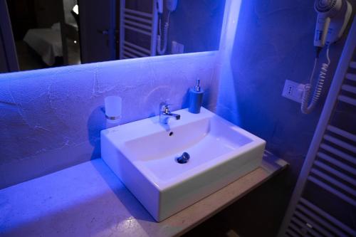 科拉托Graffiti B&B Apartments的蓝色客房内的白色水槽浴室