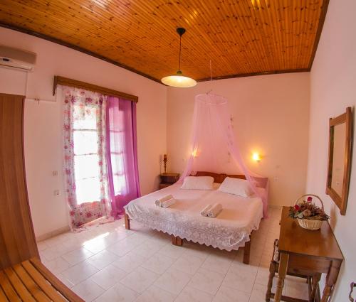 斯达林Takis Apartments的一间卧室配有一张床、一张桌子和一个窗户。