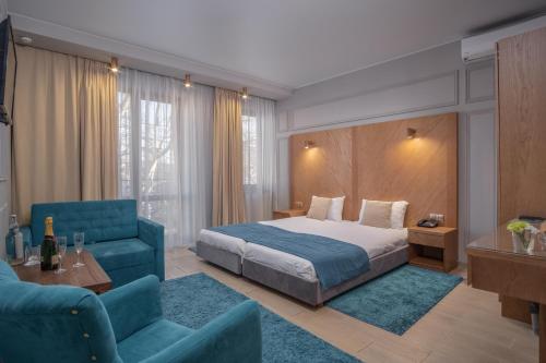 敖德萨Boomerang Boutique Hotel的酒店客房,配有床和蓝色的沙发