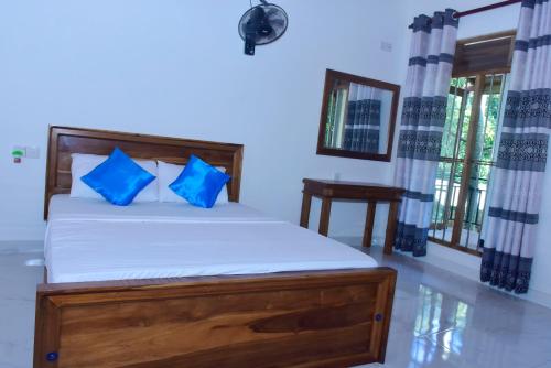 达瓦拉维Wild Heaven Udawalawe的一间卧室配有一张带蓝色枕头的床