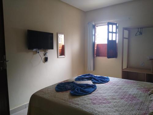 伦索伊斯Hospedaria Casa de Adriana的一间卧室配有一张床和一台平面电视