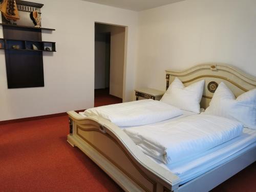 维辛Ferienwohnung Außerdorf的一间卧室配有带白色床单和枕头的床。