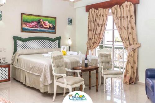 纳瓜西奈半岛酒店 的卧室配有一张床和一张桌子及椅子