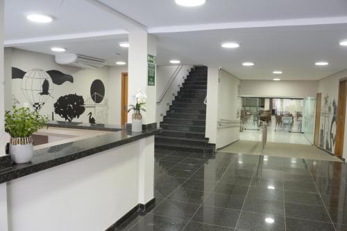 皮拉西卡巴Asa Hotel的走廊设有楼梯,大堂铺有黑色瓷砖