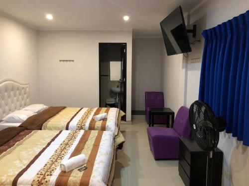 上钦查Bella Durmiente Hotel & Eventos的酒店客房设有两张床和一张紫色椅子