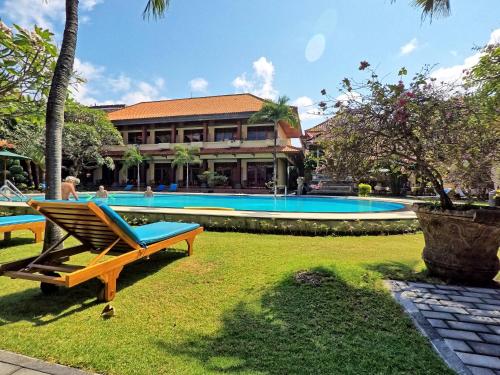 库塔Masainn Hotel Kuta的一座带游泳池和大楼的度假村