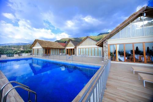 拉利贝拉Mezena Resort & SPA的一座带大型蓝色游泳池的房子