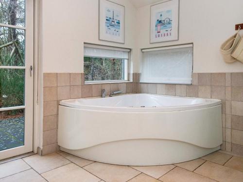 菲耶勒鲁普Four-Bedroom Holiday home in Glesborg 15的带2扇窗户的浴室内的白色大浴缸
