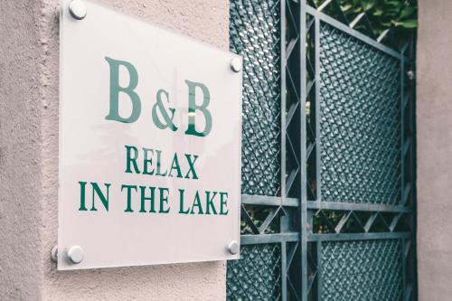 代森扎诺-德尔加达Bed&Breakfast Relax In The Lake的建筑一侧的标志,上面写着湖中放松的bc