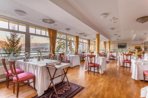 布莱德特里格拉夫酒店的餐厅设有白色的桌椅和窗户。