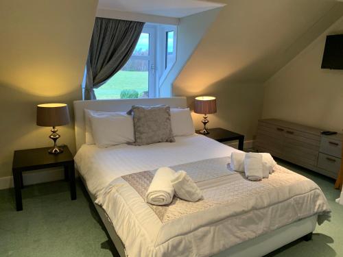 阿伯劳尔The Cottage Aberlour的一间卧室配有一张床,上面有两条毛巾