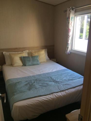 尚克林Isle of Wight Caravan的一间卧室设有一张大床和窗户