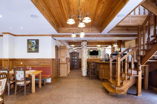 布克维Ganz SKI Lift 5的一间带木制天花板和楼梯的用餐室
